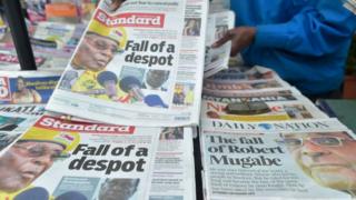 A newspaper vendor arranges local dailies with headlines about the situation in Zimbabwe on November in Nairobi