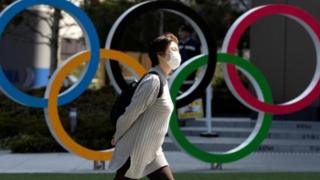 امرأة ترتدي كمامة أمم شعار الألعاب الأولمبية
