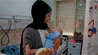 شابة فلسطينية تتطوع كأم بديلة لرضيع من غزة يعالج وحيدا في الخليل