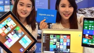 Dos mujeres muestran el sistema Windows en diferentes dispositivos