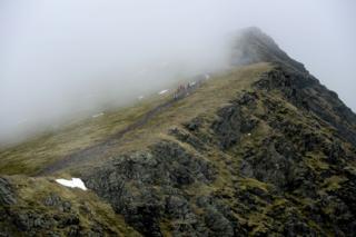 Walkers on a path on a mountain ridge in Britain