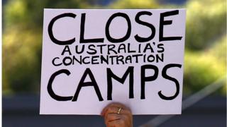 A placard reading 'close Australia's concentration camps' is held up during a rally in support of refugees in central Sydney