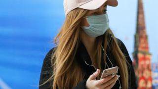 Woman with face mask and phone