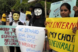 Индийские активисты носят маски, поскольку держат плакаты во время демонстрации в поддержку «сетевого нейтралитета» в Бангалоре