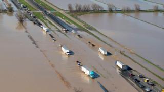 Vehicles trying to negotiate flooded Interstate 5 in Williams, north California, where more rain is expected