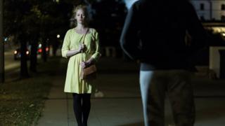 Mujer con miedo caminando de noche pro la calle