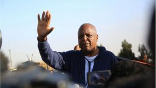 ደ/ር መረራ ጉዲና ለደጋፊዎቻቸው ሰላምታ ሲሰጡ