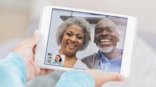 Technology A stock photo shows two older people on a tablet, calling a younger person