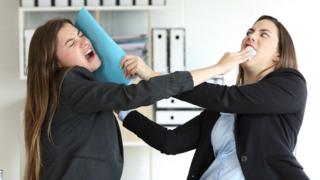 Dos mujeres peleando en la oficina.