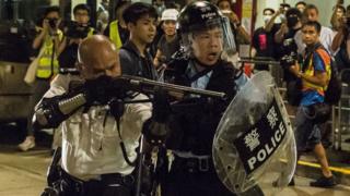 At the police station in the new territory of Hong Kong, the police sergeant (on the left) raised lightning and gun to guide demonstrators (30/7/2019)