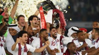 The Qatari team holds the Asian Cup on the podium