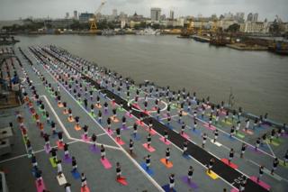 Indian Armed Forces personnel take part in a yoga sesssion to mark International Yoga Day on the Indian Navy aircraft carrier INS Viraat anchored at the Mumbai harbour on June 21, 2017