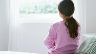 A child sitting on a bed