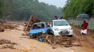 A man stands next to damaged cars after a landslide caused by torrential monsoon rains at Puthumala near Meppadi, Wayanad district, in the southern state of Kerala, India, August 14, 2019