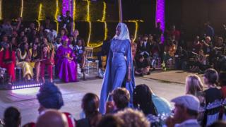 A model walks on a catwalk wearing a design from Senegalese fashion label So' Fatoo during Dakar Fashion Week in Dakar, Senegal
