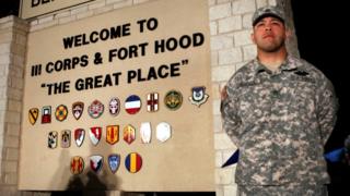 Erick Rodriguez stands guard at the entrance to Fort Hood Army base in Texas