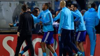 Compañeros apartan a Evra después de la patada.