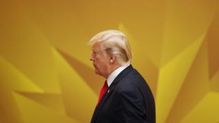 Дональд Трамп на встрече АТЭС во Вьетнаме, на фоне оранжево-желтого звездного фона
