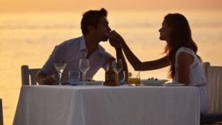 A couple enjoying a romantic dinner on the beach