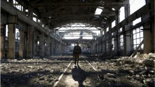 Український військовий йде через зруйнований внаслідок боїв цех в Авдіївці, 31 березня 2017 року.