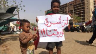 طفلان سودانيان يحملان لافتة ثورية