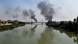 Smoke billows from burning tyres blocking a bridge over the Euphrates River in the centre of the southern Iraqi city of Nasiriyah where demonstrators carried on with anti-government protests on November 12, 2019