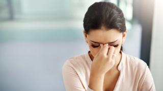 Mujer joven con dolor de cabeza.