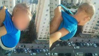 أب يدلي طفله من النافذة