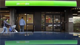 woman with pushchair and man walking into a job centre