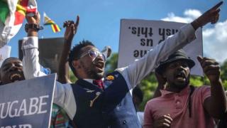 People and soldiers celebrate after the resignation of Zimbabwe"s president Robert Mugabe on November 21, 2017 in Harare.