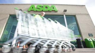 Asda employee collects trolleys