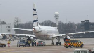 Photograph shows security vehicles near to aircraft
