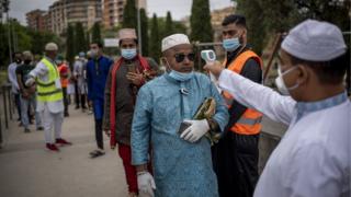 Die Mitarbeiter verwenden einen Thermoscanner, um die Körpertemperatur der Muslime während der Feier des Eid al-Fitr in Rom zu überprüfen