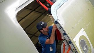 Homem ajustando porta de avião