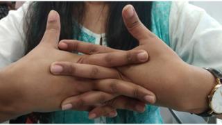 చేతి వేళ్లు విరుస్తున్న మహిళ