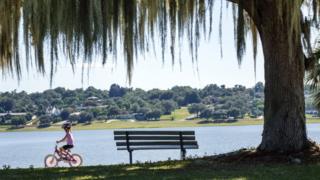 Menina anda de bicicleta em parque nos EUA