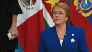 Bachelet detrás de unas banderas