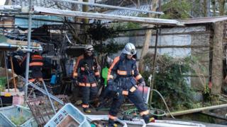 Firefighters investigate a partly burned and collapsed house on January 02, 2024 in Nanao, Japan. T