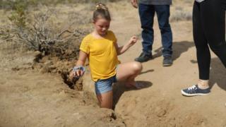 Una niña que vive en Ridgecrest introduce su pierna en la grieta creada tras el terremoto.