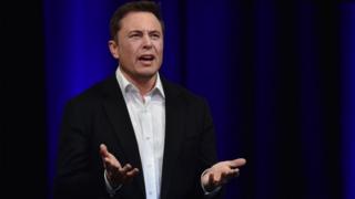Elon Musk looks annoyed and gesticulates with his hands