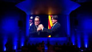 Лидер Каталонии, Карлес Пуигдемонт (справа), на большом экране. запланировано на мероприятие в Барселоне, 13 января 2018 года