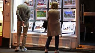 Couple looking in estate agent window
