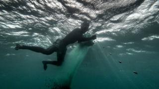 Fisherman tends to his net in the sea.