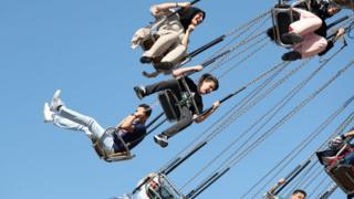 İstanbul'da bayram tatilinde gençler bir lunaparktaki salıncağa binerken