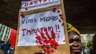 Mujer con letrero de"Las vidas negras importan"