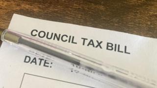 The top of a council tax bill with a pen resting on top of it.