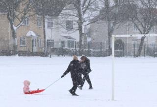 Parents and children enjoying the snow