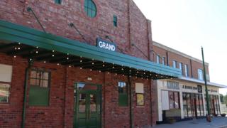 A parade of shops featuring a cinema, milkbar and toy shop