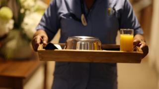 Carer walking with a tray of food