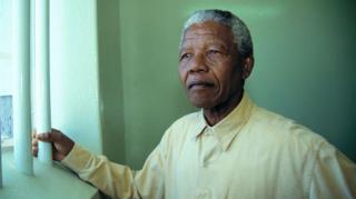 Nelson Mandela looking out of a barred window